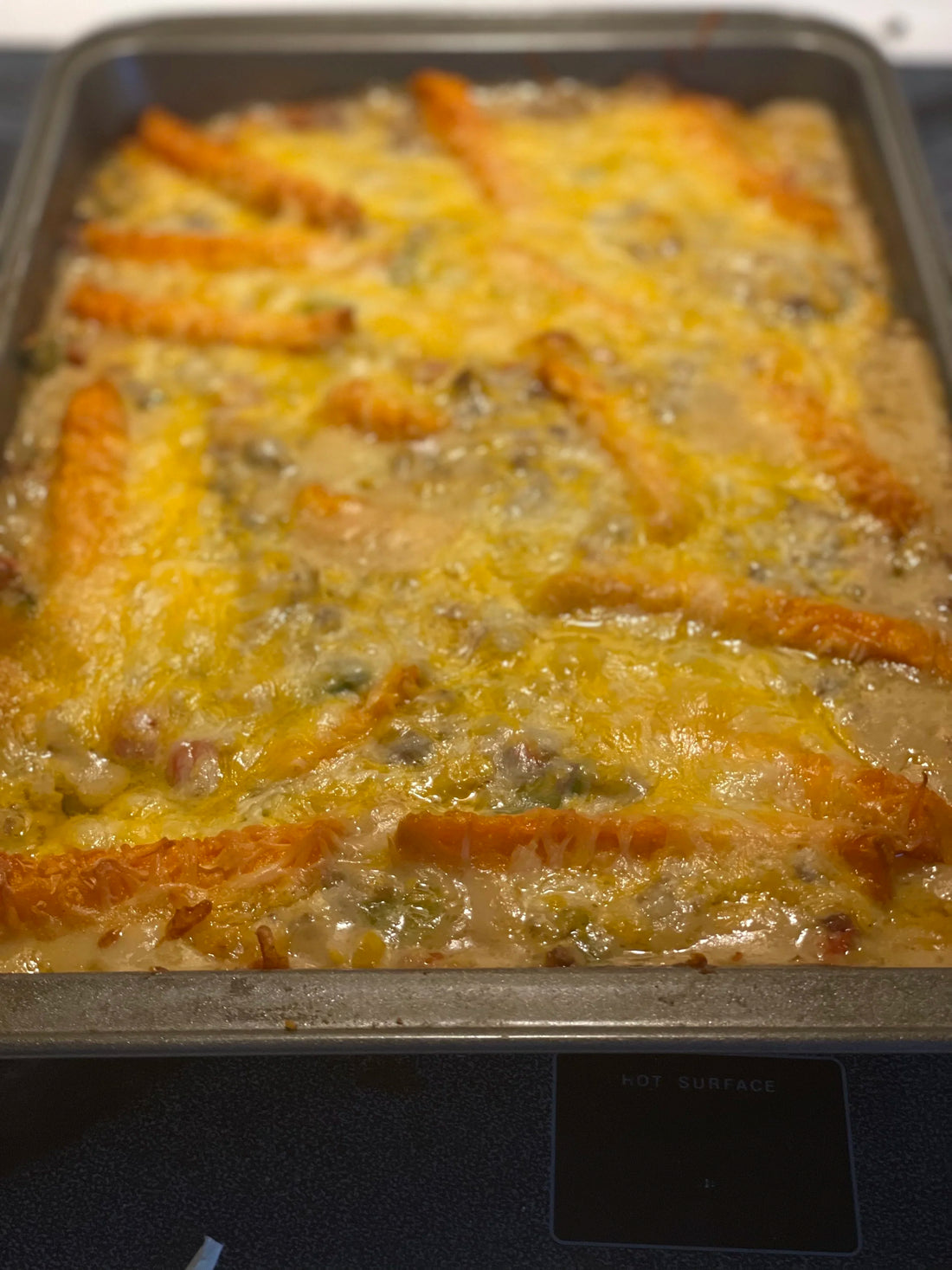 Cowboy casserole topped with tator tots and cheese